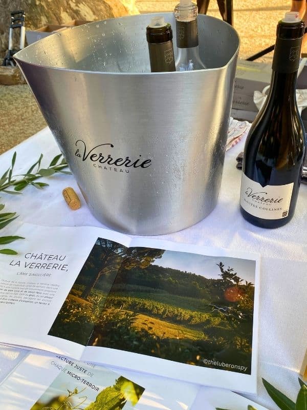 Chateau La Verrerie items on a table: magazine, bucket of ice, and wine bottle. This was for the brand's wine testing booth at a wine festival this writer attended.