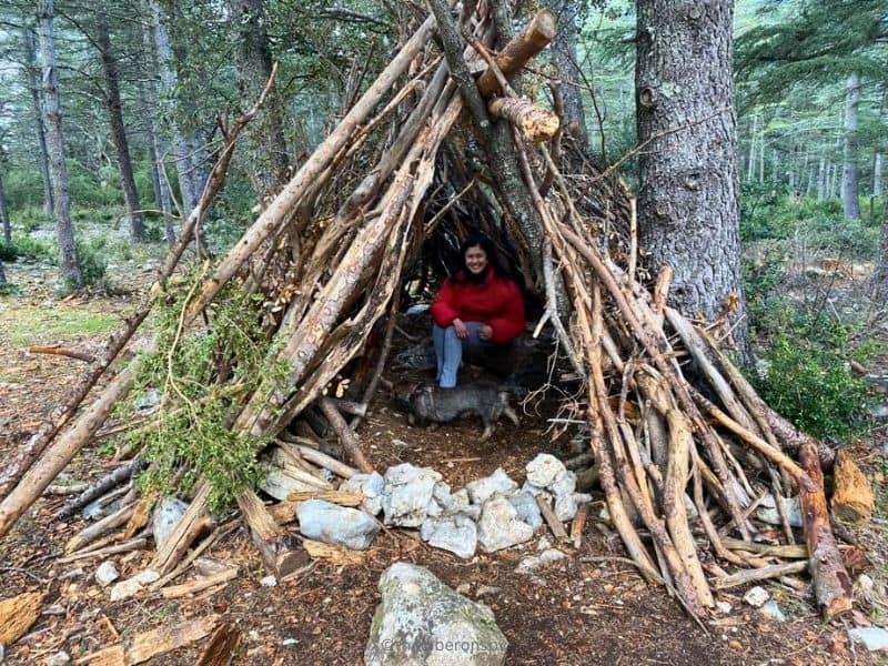 The writer (and her dog) sitting inside a wooden tent at the Cedar Forest in the Luberon.