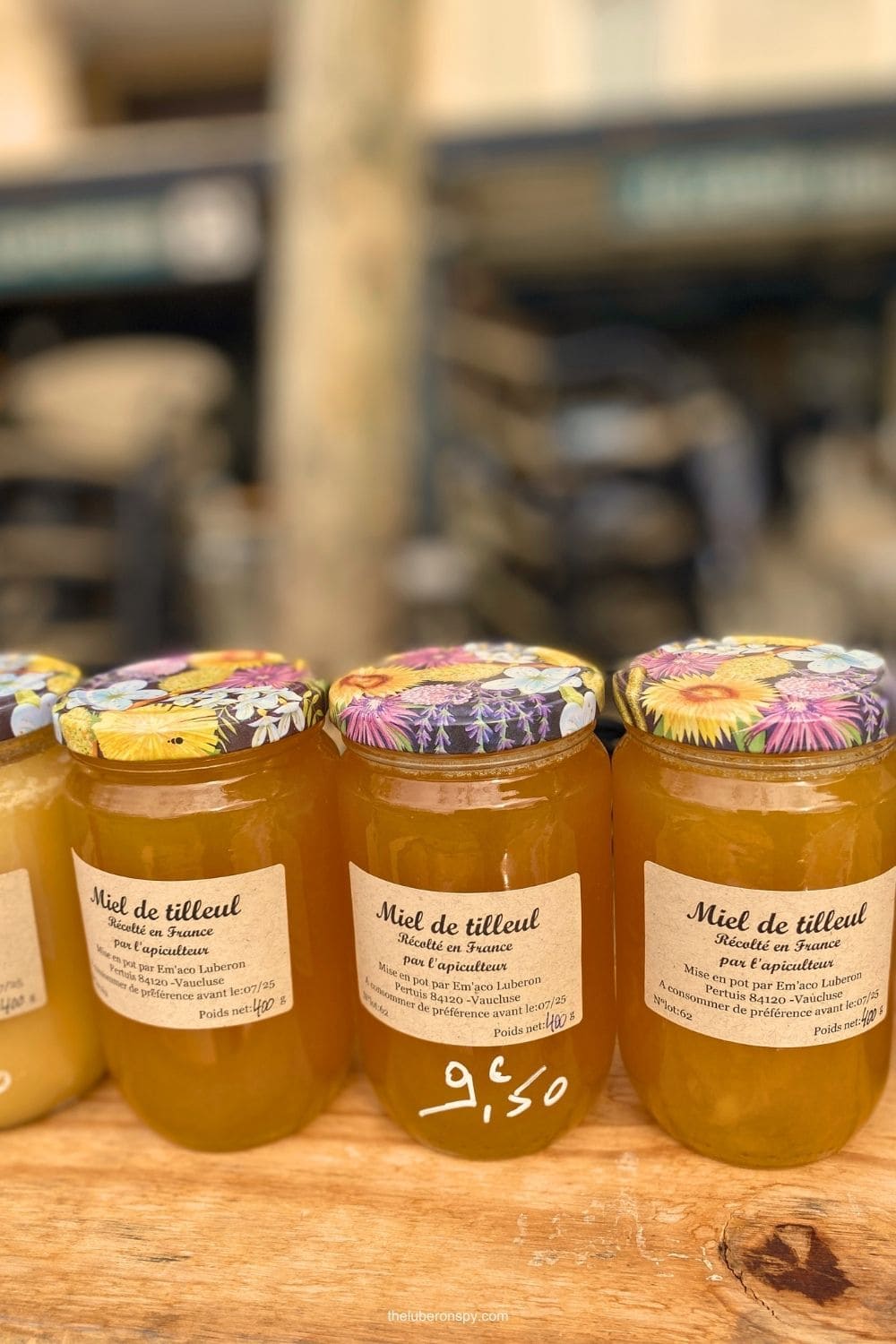Jars of golden linden honey labeled "Miel de tilleul" sold at a market stall in Lourmarin
