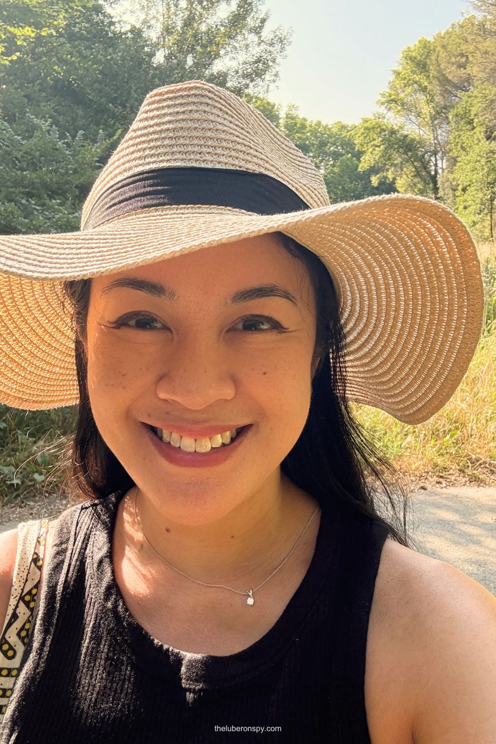 A smiling woman, writer of The Luberon Spy, wearing a wide brimmed straw hat in Lourmarin.